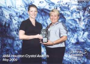 From left to right: Deanna Wilke, Account Manager and Mandy Pierson, Office Manager, accept the 2009 AMA Crystal Award on behalf of the agency.